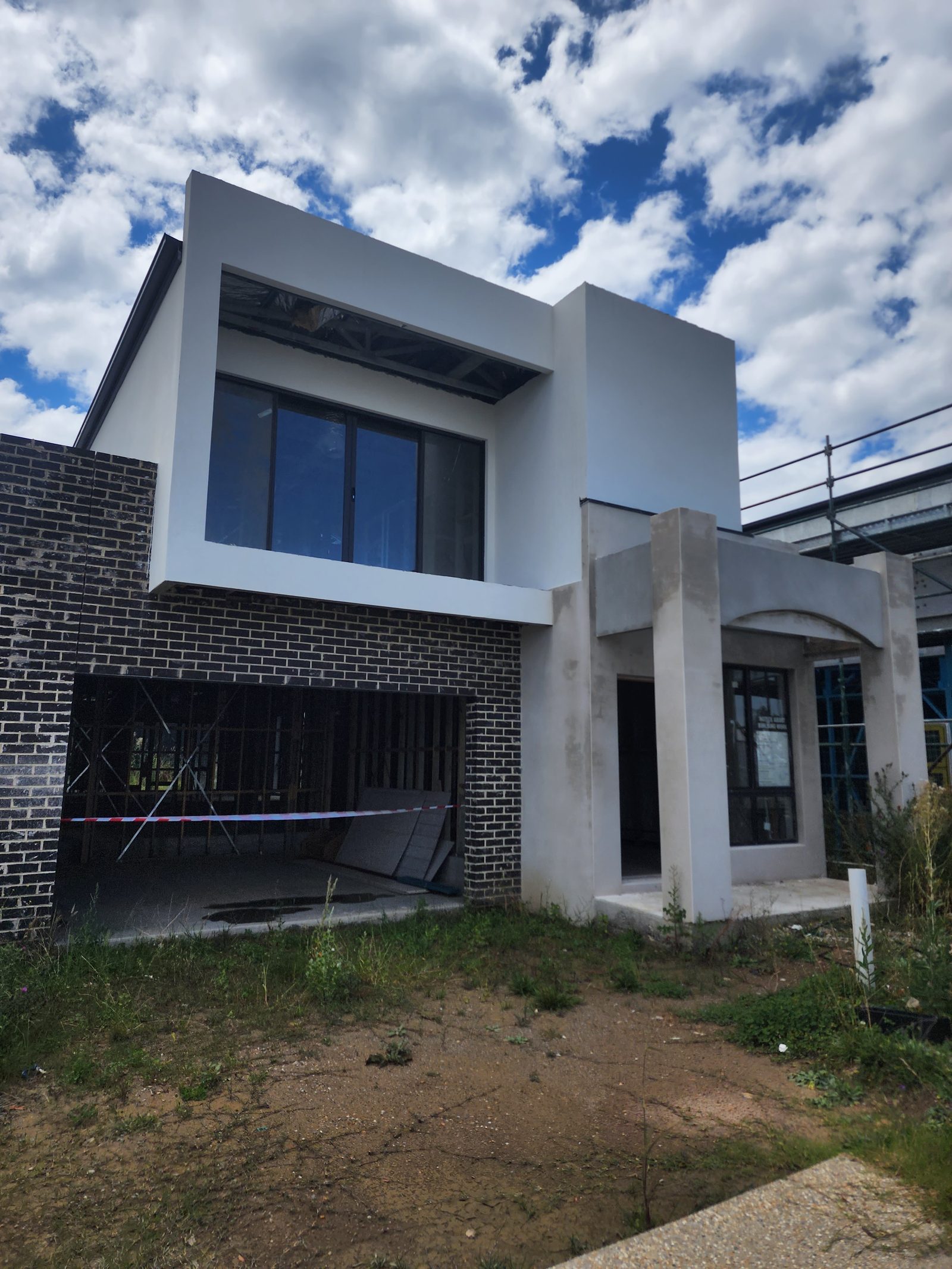 New home render in progress — white render with dark brick