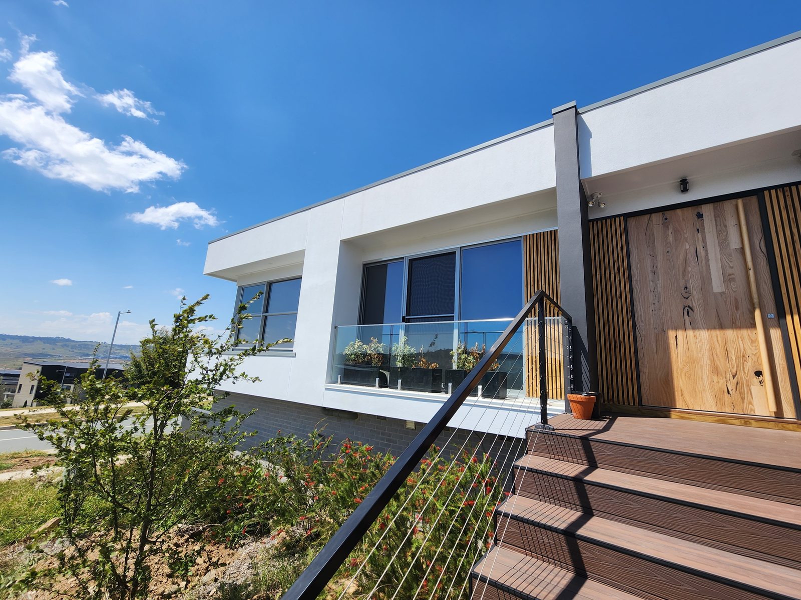Modern home exterior renovation — black, white and timber facade